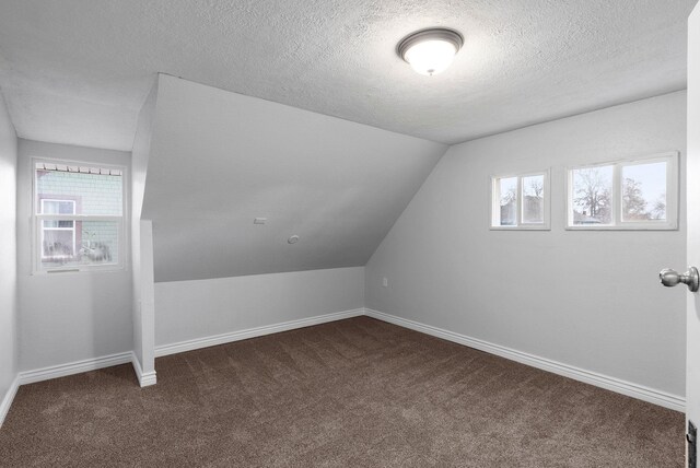 carpeted empty room featuring a textured ceiling