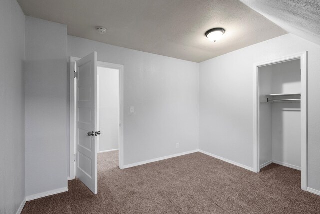 unfurnished bedroom with carpet, a textured ceiling, and a closet