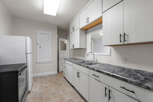 kitchen with white cabinetry, sink, and white appliances