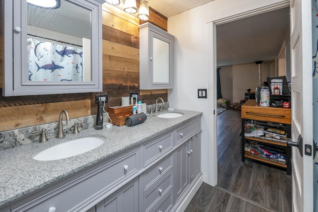 bathroom featuring wooden walls, hardwood / wood-style floors, and vanity