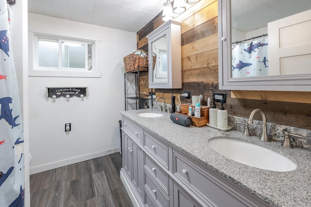 bathroom with hardwood / wood-style floors, vanity, and wood walls