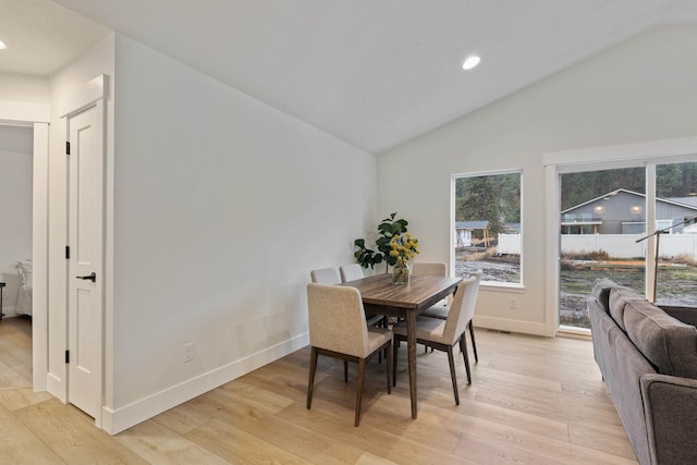 dining room with vaulted ceiling and light hardwood / wood-style flooring