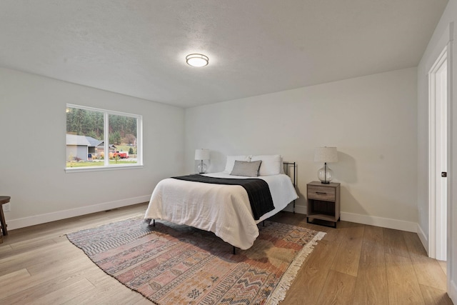 bedroom featuring light wood-type flooring and a textured ceiling