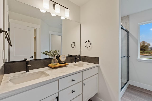 bathroom featuring wood-type flooring, vanity, and a shower with shower door