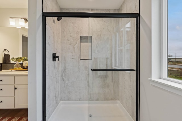 bathroom with hardwood / wood-style floors, vanity, and a shower with shower door