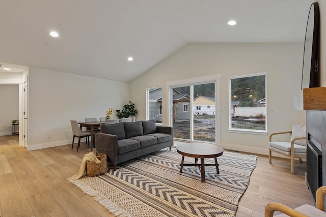 living room featuring light wood-type flooring and vaulted ceiling