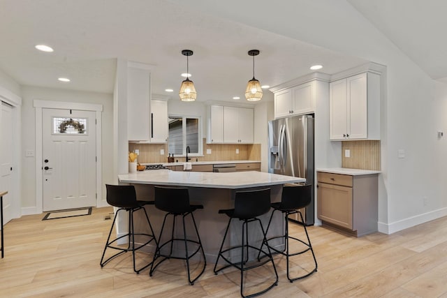 kitchen with white cabinetry, stainless steel appliances, and light hardwood / wood-style flooring