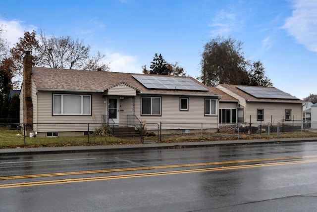 ranch-style house featuring solar panels