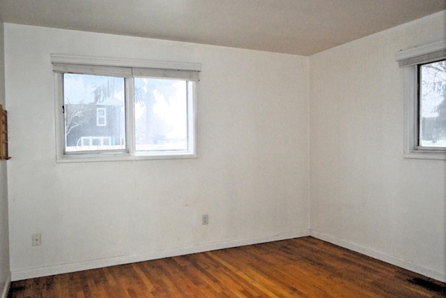 unfurnished room with dark hardwood / wood-style flooring