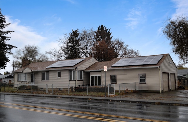 view of front facade featuring a garage and solar panels