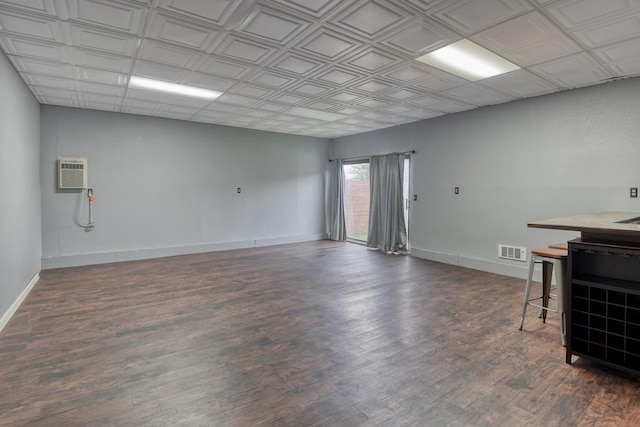 interior space with a wall mounted air conditioner and dark hardwood / wood-style flooring