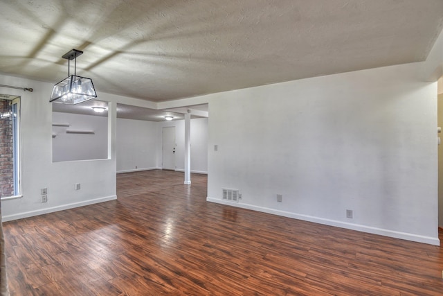 empty room featuring dark hardwood / wood-style flooring and a textured ceiling