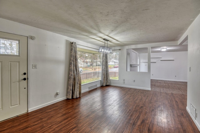 foyer with dark hardwood / wood-style flooring and a textured ceiling