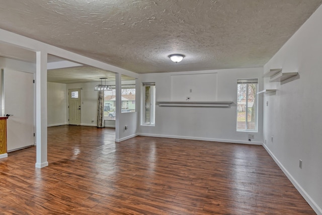 unfurnished living room featuring a textured ceiling and dark wood-type flooring