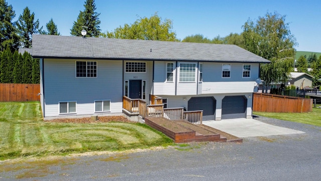 bi-level home with a garage and a front lawn