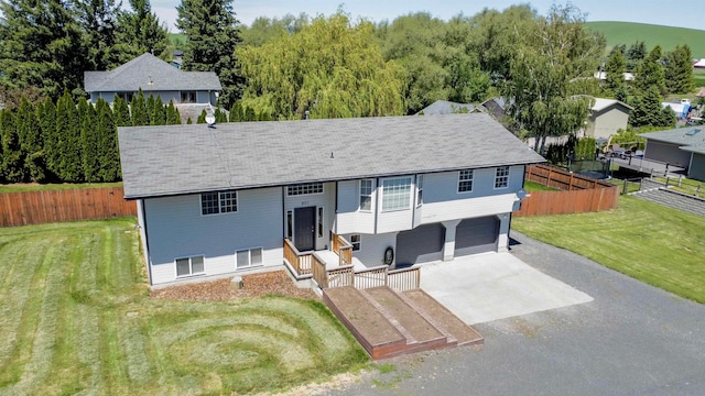 split foyer home featuring a garage and a front lawn