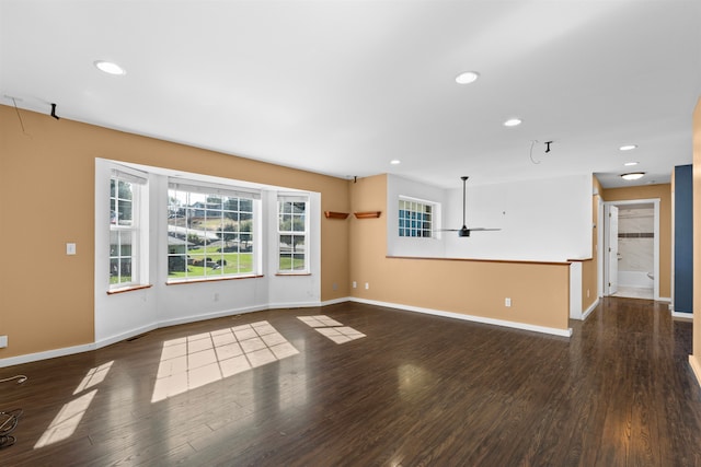 unfurnished living room with dark hardwood / wood-style flooring and ceiling fan