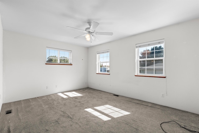 carpeted spare room featuring ceiling fan