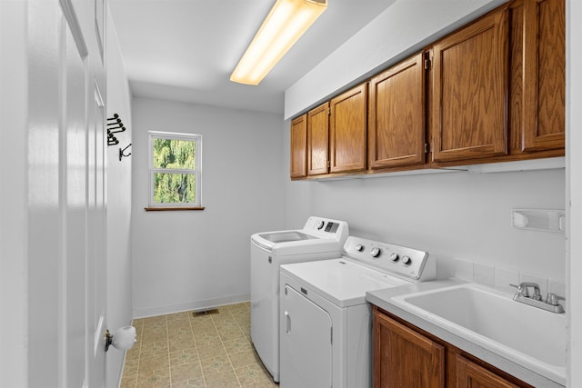 clothes washing area with light tile patterned flooring, cabinets, independent washer and dryer, and sink