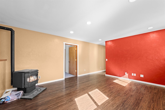 unfurnished living room with a wood stove and wood-type flooring