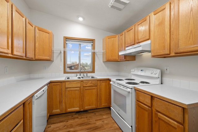 kitchen with light wood-type flooring, white appliances, lofted ceiling, and sink