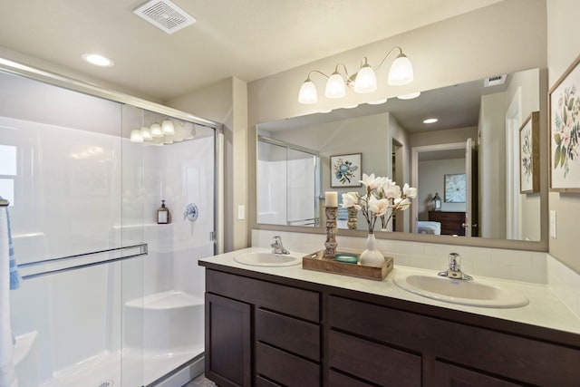 bathroom with tasteful backsplash, a shower with door, and vanity