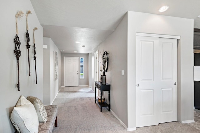 carpeted foyer entrance featuring a textured ceiling