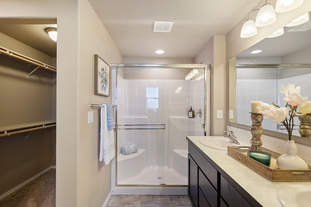 bathroom with a shower with door and vanity