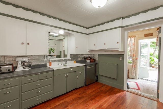 kitchen featuring decorative backsplash, dark hardwood / wood-style flooring, sink, dishwasher, and white cabinets