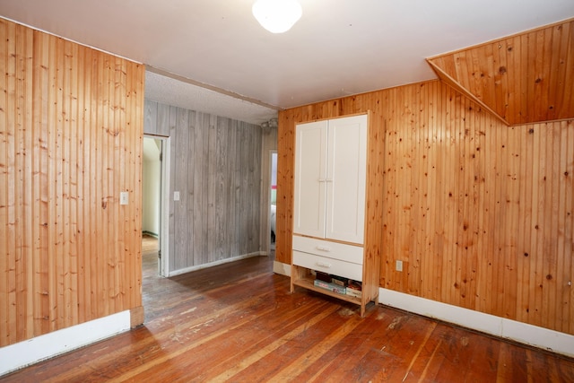 spare room featuring wood-type flooring and wooden walls