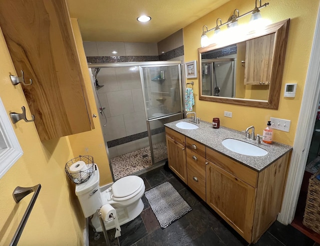 bathroom with vanity, toilet, and a shower with door