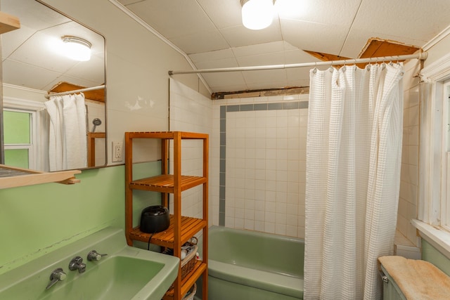 bathroom with shower / bath combo, sink, lofted ceiling, and ornamental molding