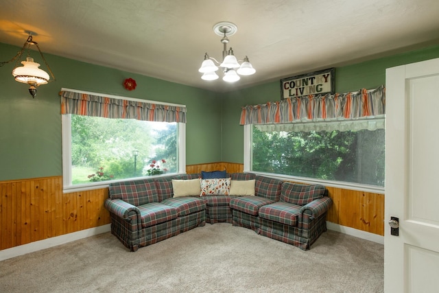 living room with carpet floors, wooden walls, and a chandelier