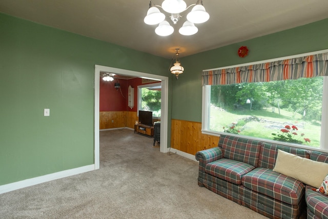 sitting room featuring a chandelier, carpet floors, and wood walls