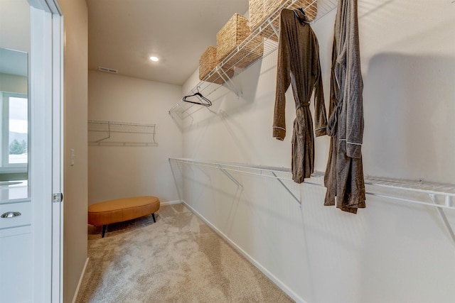 walk in closet featuring light carpet