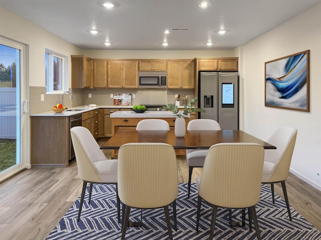 kitchen with appliances with stainless steel finishes, backsplash, a center island, and a wealth of natural light