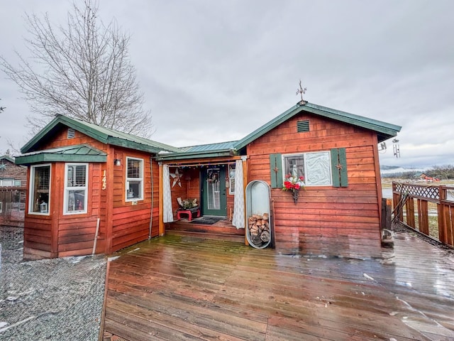 rear view of property featuring a wooden deck