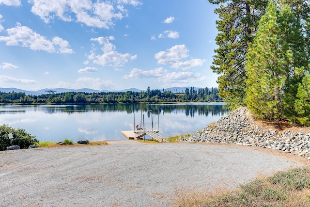 water view featuring a mountain view and a dock