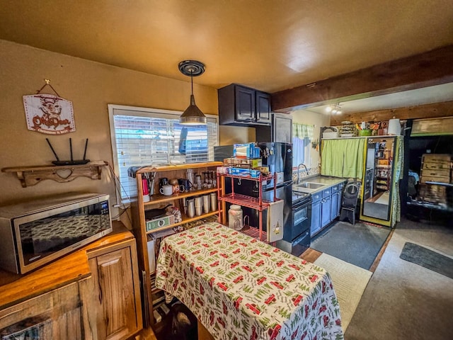 kitchen with beam ceiling, decorative light fixtures, and sink