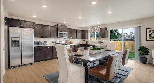 kitchen featuring decorative backsplash, dark brown cabinetry, stainless steel appliances, and light hardwood / wood-style flooring