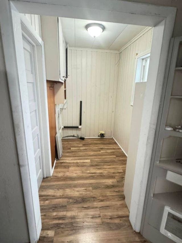 clothes washing area with dark hardwood / wood-style floors and wooden walls