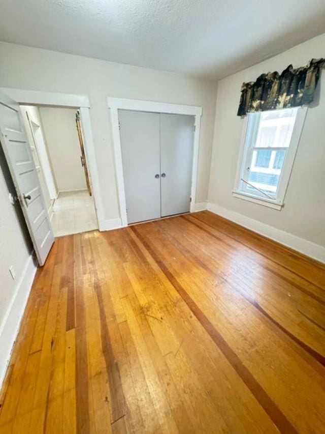 202 S Central Ave, Ione, WA 99139 - unfurnished bedroom with light wood finished floors, a closet, and a textured ceiling