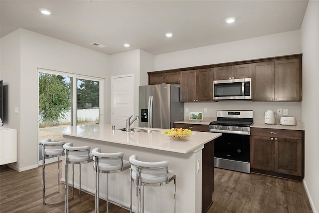 kitchen featuring a center island with sink, dark hardwood / wood-style floors, and appliances with stainless steel finishes