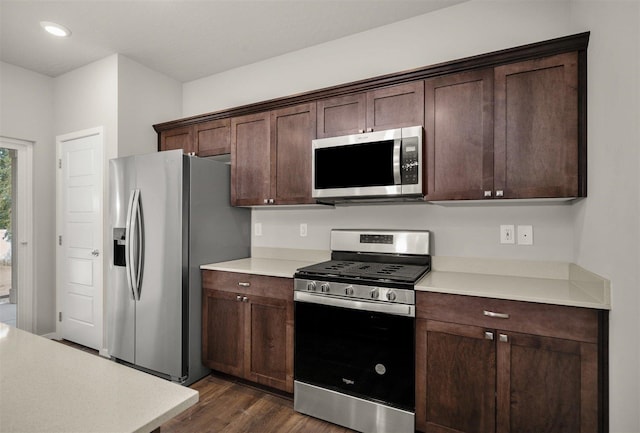 kitchen featuring dark brown cabinetry, dark hardwood / wood-style floors, and appliances with stainless steel finishes