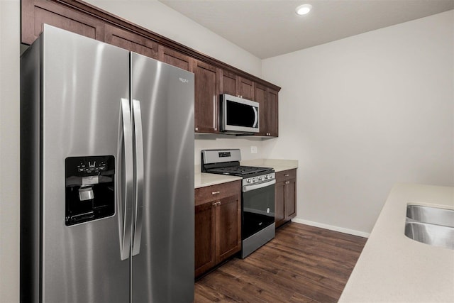 kitchen featuring dark hardwood / wood-style floors, dark brown cabinets, sink, and appliances with stainless steel finishes