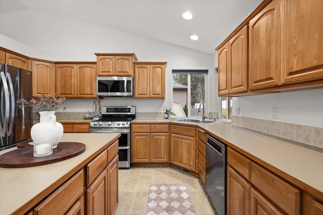 kitchen with sink, light tile patterned floors, stainless steel appliances, and vaulted ceiling