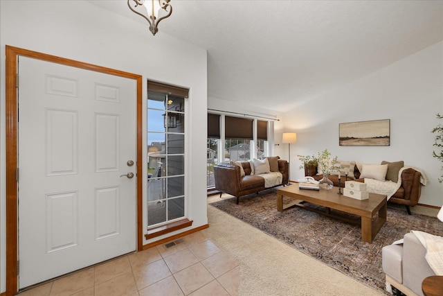 foyer with light tile patterned floors and vaulted ceiling