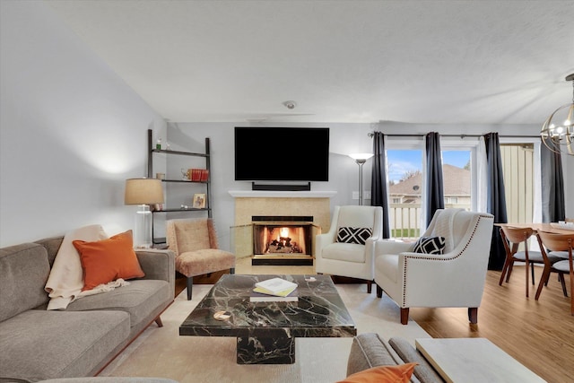 living room featuring light wood-type flooring and a notable chandelier