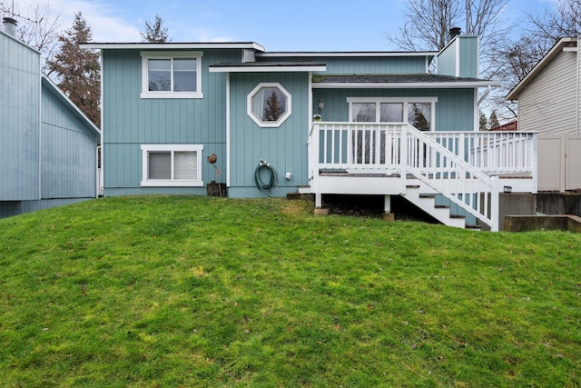 rear view of house featuring a yard and a wooden deck