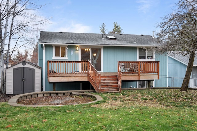 rear view of property featuring a lawn, a storage shed, and a deck